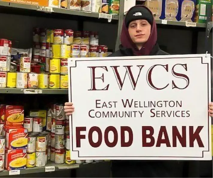 person holding EWCS food bank sign